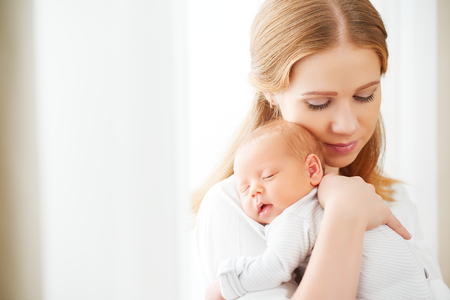 50843762 – newborn baby in a tender embrace of mother at the window