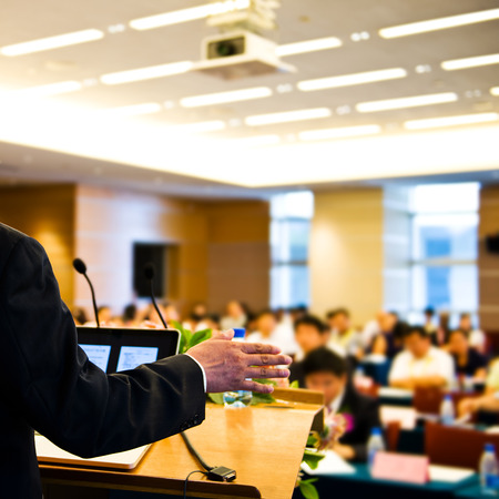 37297008 – business man making speech at a conference hall.